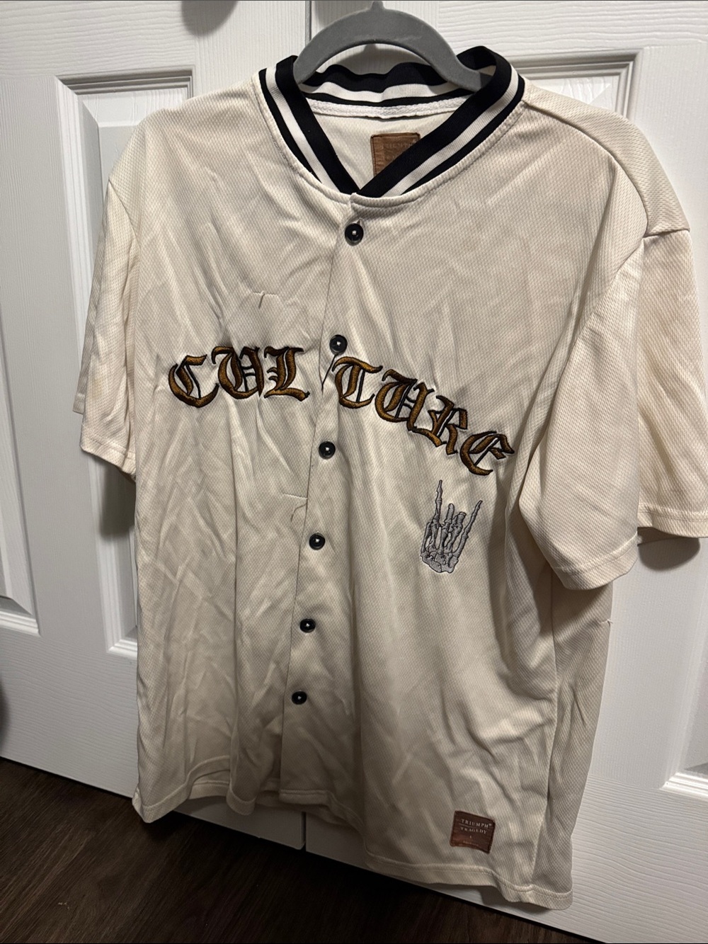Triumph Cream Baseball Jersey with Black Trim and Gold Embroidery